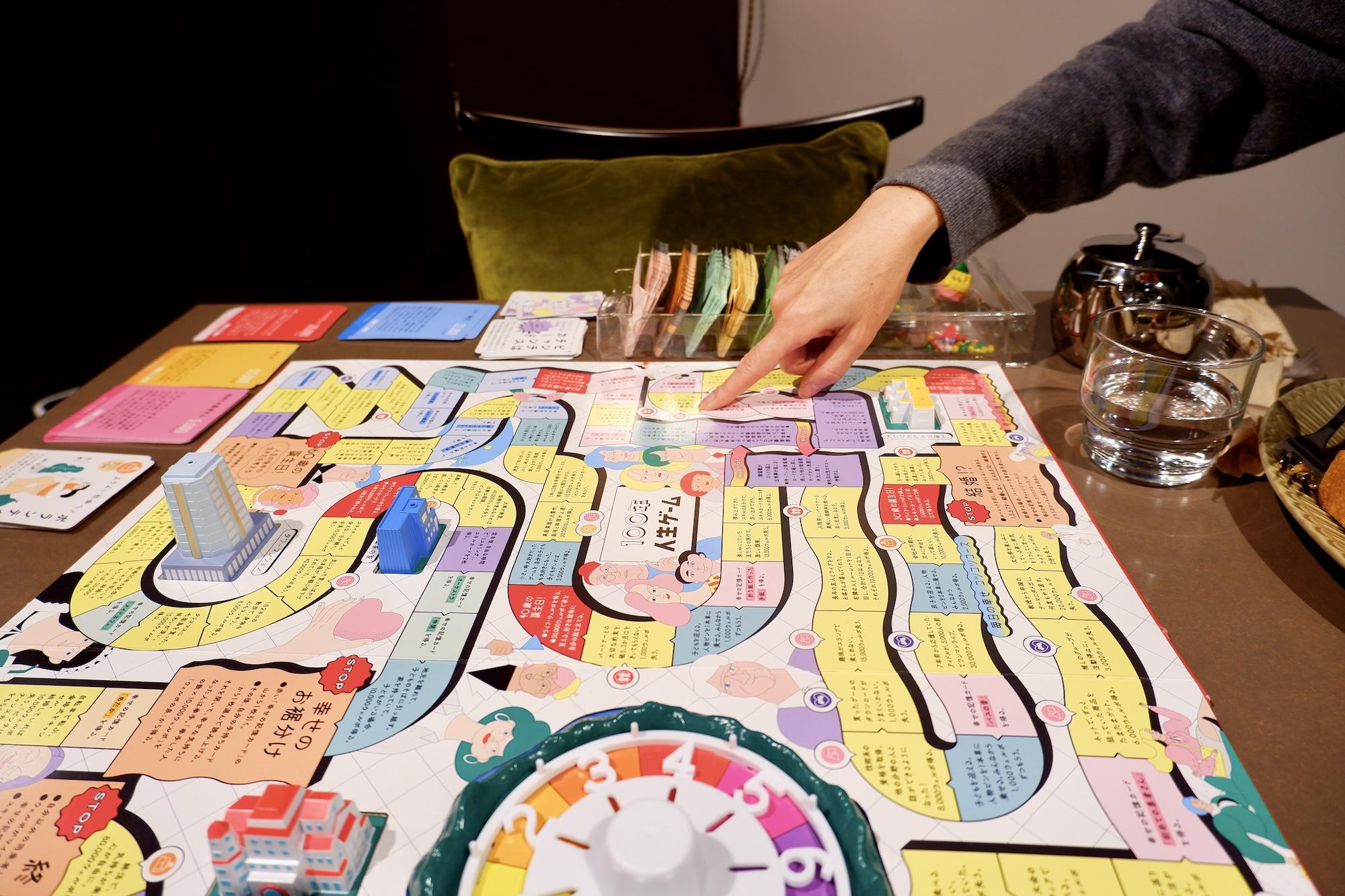 人生ゲーム新作は「億万長者を目指さない」。通貨は“幸福度”、実話が